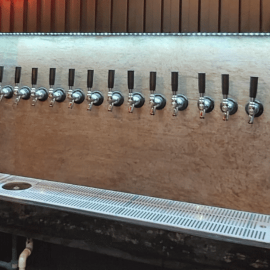 Punto de servicio de cerveza con grifos y charolas de una instalación de dispensado con cámara fría TBD